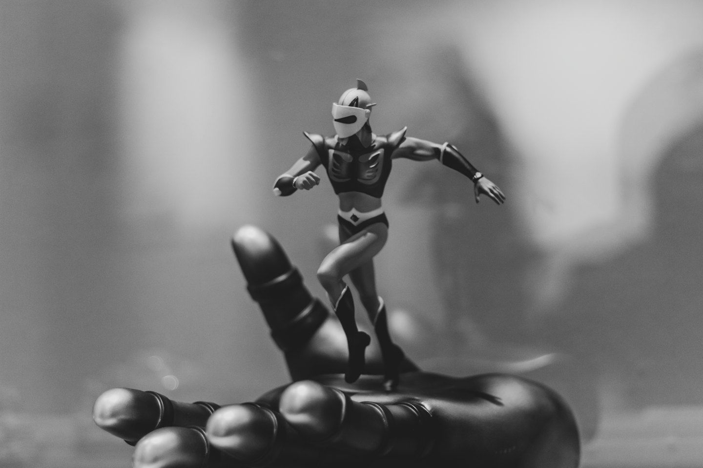 Superhelden-Actionfigur läuft auf einer metallischen Handskulptur.
