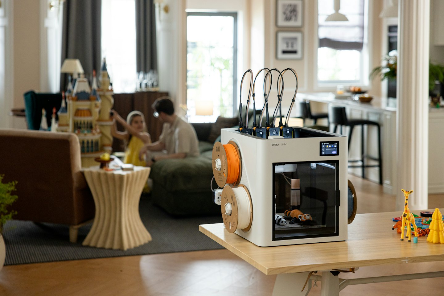 3D-Drucker erstellt Spielzeug auf einem Holztisch.