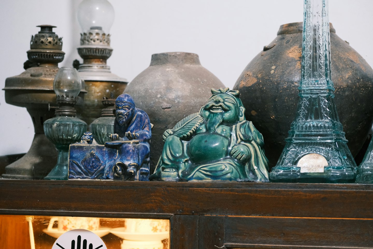 Antike Keramikstatuen und Öllampen auf einem Holzregal.