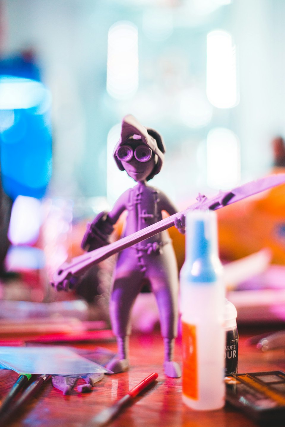 Fantasy-Figur mit Schutzbrille und Stab auf einem Holztisch.